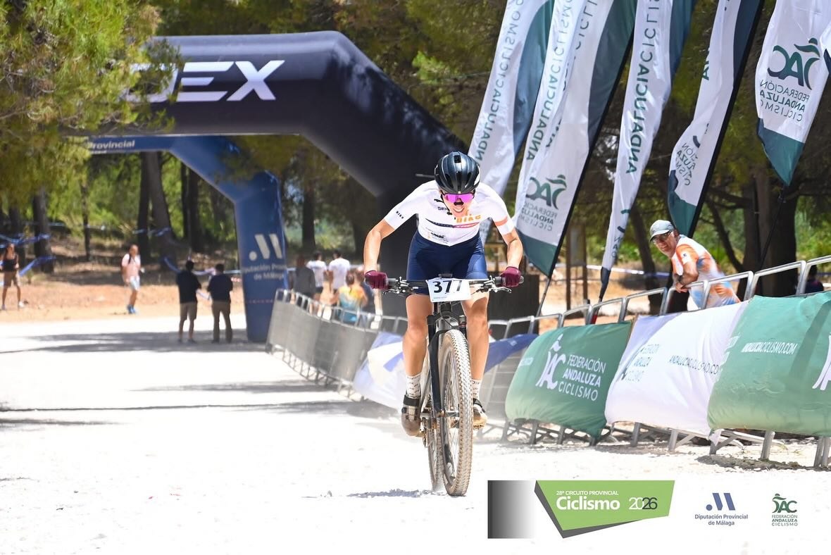 Ana Gay sprinting on her mountain bike towards the finish arch